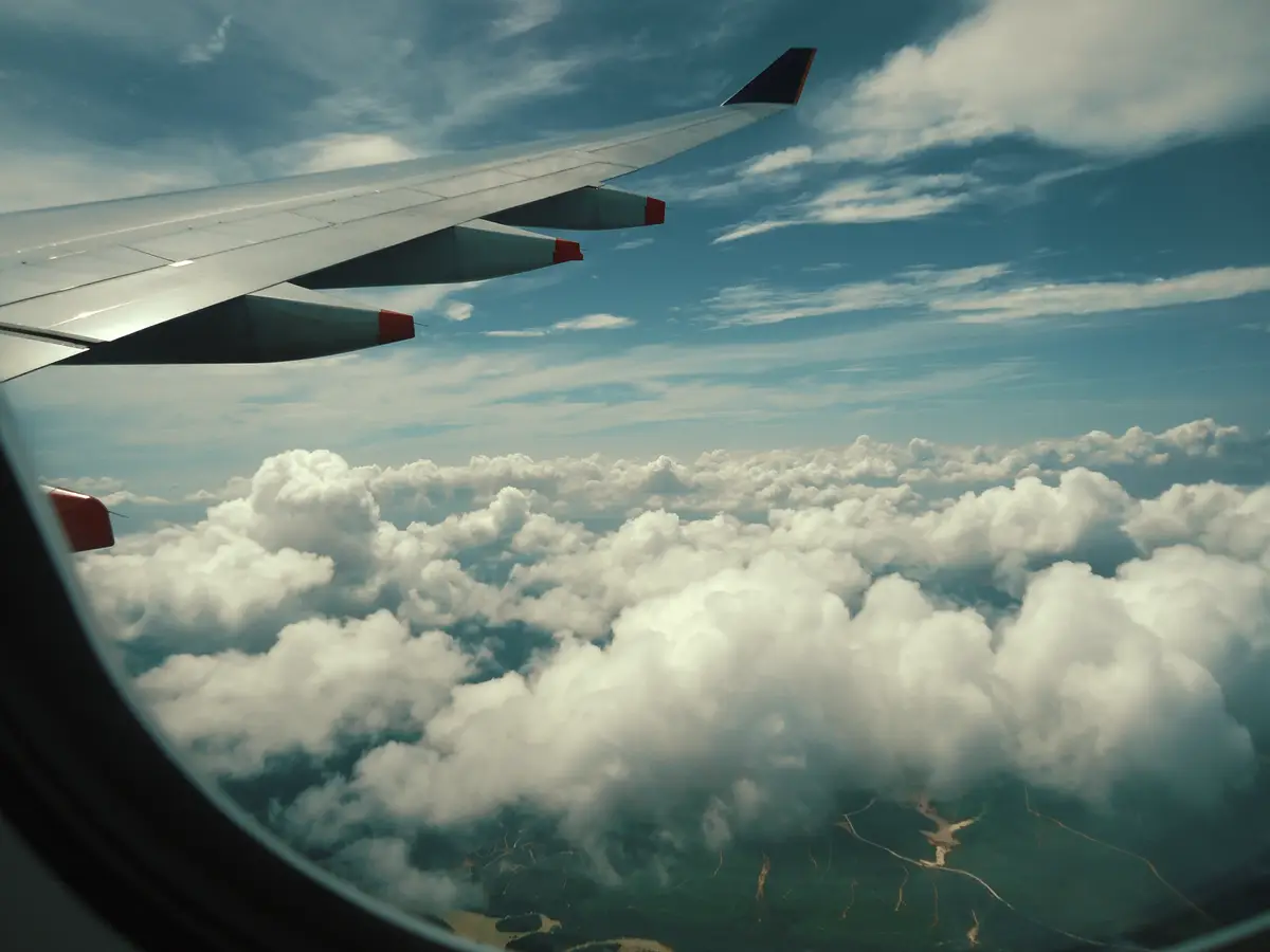 飛行機の窓から見える主翼と雲